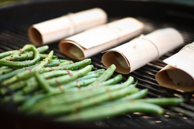 Fresh green asparagus being prepared with parchment paper, ideal for healthy cooking and gourmet dishes at Cedar Works.
