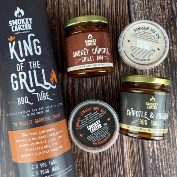Smokey Carter barbecue sauces and chilli jam set on rustic wooden background, showcasing flavorful BBQ rubs, chipotle chili jam, and gourmet BBQ sauces for grilling enthusiasts and home chefs.