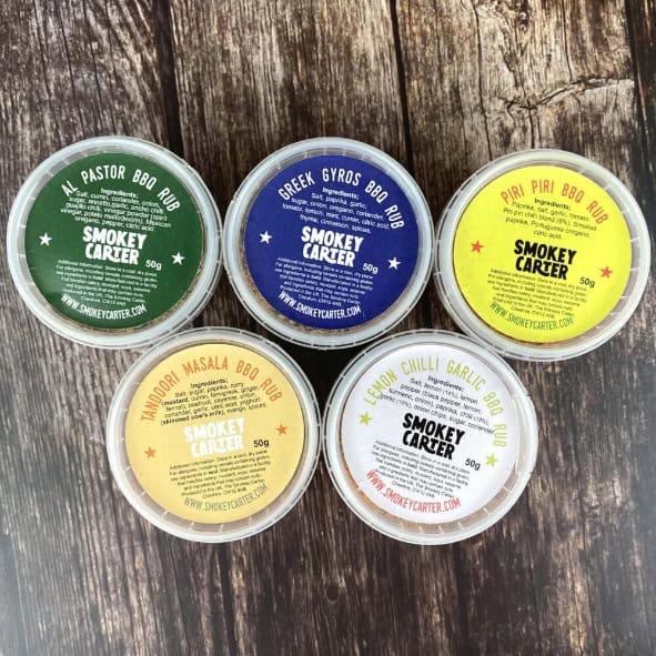 Smokey Carter BBQ rubs in colorful containers, ideal for grilling and barbecue enthusiasts, offered by Cedar Works New Zealand.